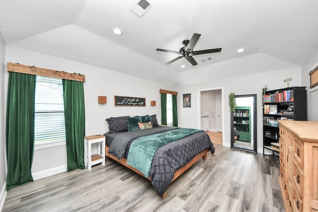 bedroom with visible vents, lofted ceiling, a tray ceiling, light wood-type flooring, and recessed lighting