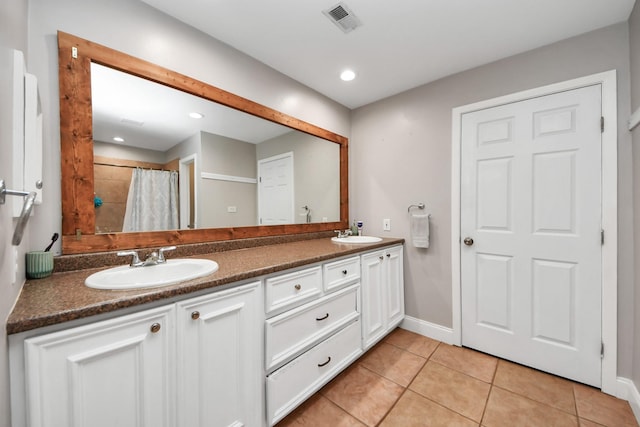 full bathroom with double vanity, a sink, visible vents, and tile patterned floors