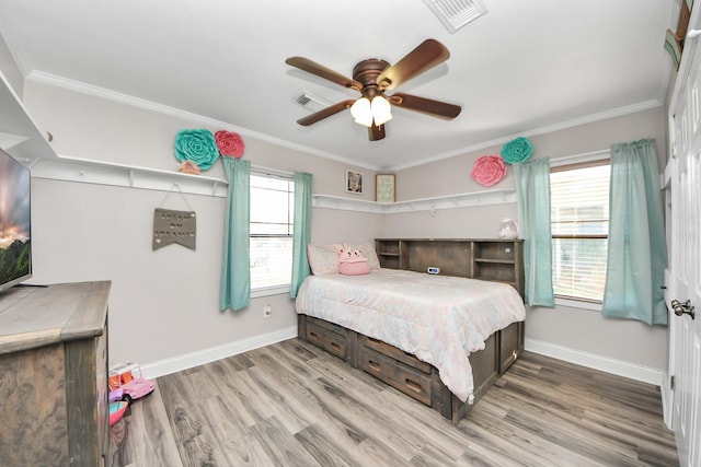 bedroom featuring multiple windows, visible vents, and crown molding