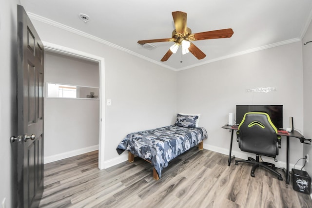 bedroom featuring baseboards, ceiling fan, light wood finished floors, and crown molding