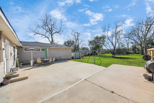 view of patio with a playground, an outdoor structure, a shed, a trampoline, and outdoor dining space