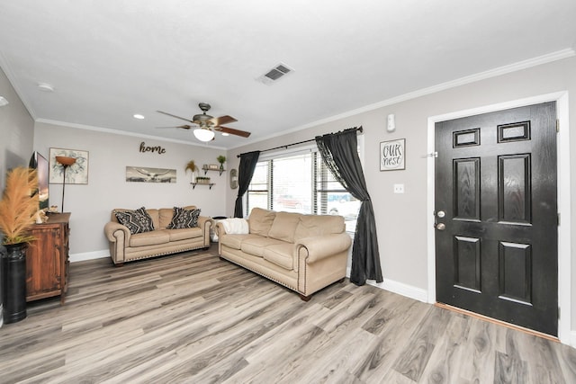 living area with crown molding, visible vents, a ceiling fan, light wood-type flooring, and baseboards