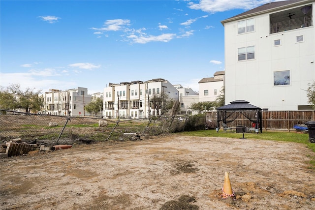 surrounding community with a gazebo, fence, and a residential view