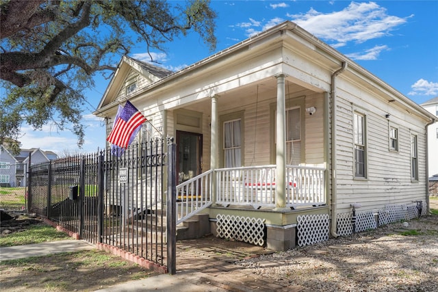 view of front of house featuring covered porch, crawl space, and fence