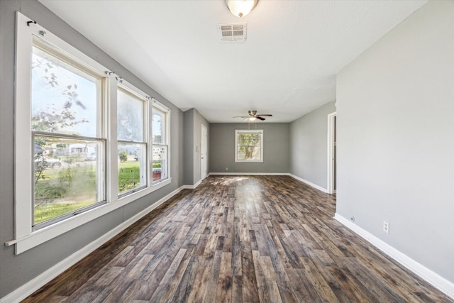 interior space featuring dark wood-style floors, baseboards, visible vents, and ceiling fan