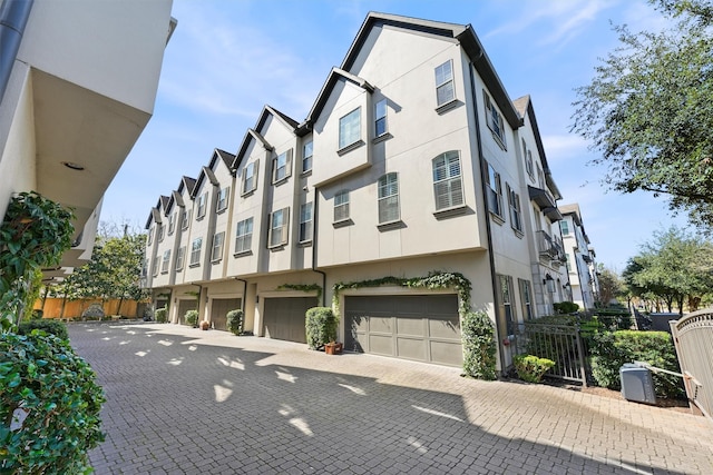 exterior space featuring a garage, fence, and a residential view