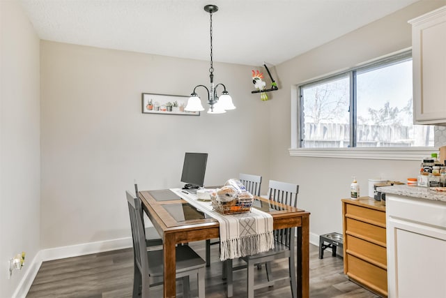 dining space featuring an inviting chandelier, wood finished floors, and baseboards