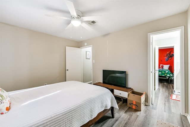 bedroom with visible vents, ceiling fan, and wood finished floors