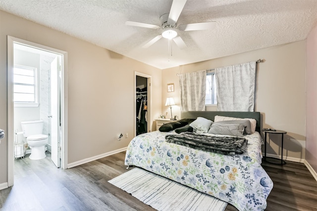 bedroom featuring a textured ceiling, a spacious closet, a closet, and wood finished floors