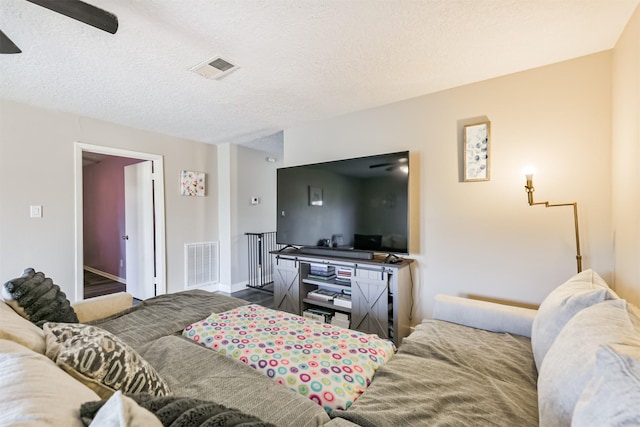 bedroom featuring visible vents, ceiling fan, and a textured ceiling