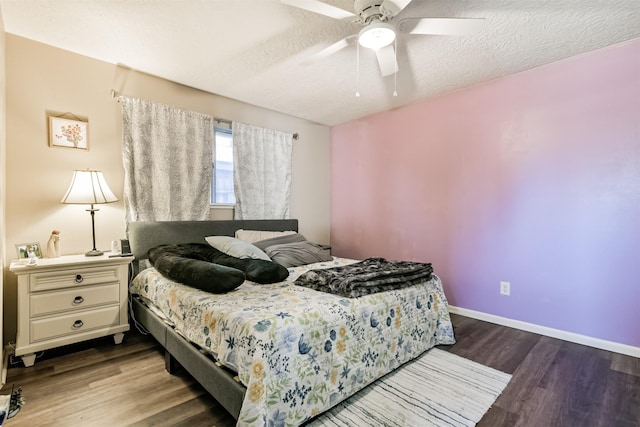 bedroom featuring a textured ceiling, baseboards, and wood finished floors