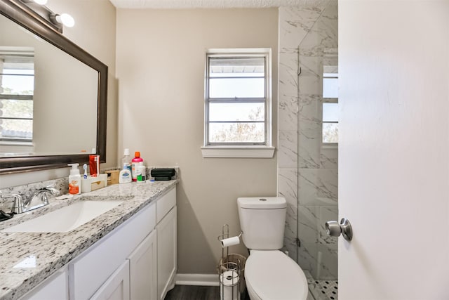 bathroom with toilet, baseboards, and vanity