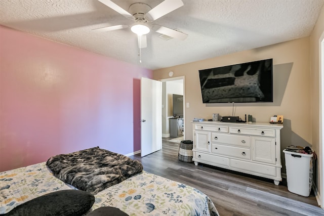 bedroom featuring dark wood finished floors, a textured ceiling, baseboards, and ceiling fan