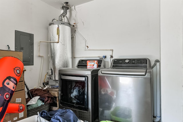 clothes washing area featuring water heater, laundry area, electric panel, and washer and dryer