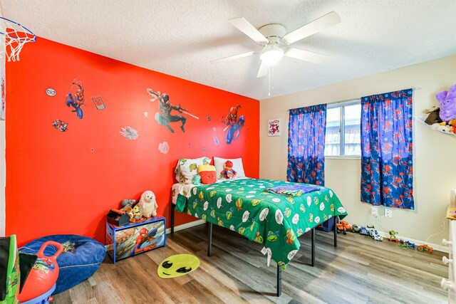 bedroom featuring a textured ceiling, ceiling fan, wood finished floors, and baseboards