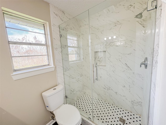 bathroom featuring a marble finish shower and toilet