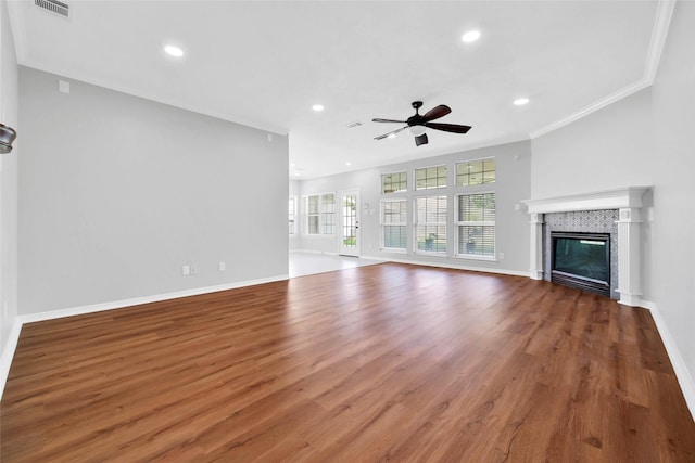 unfurnished living room featuring baseboards, a glass covered fireplace, wood finished floors, crown molding, and recessed lighting