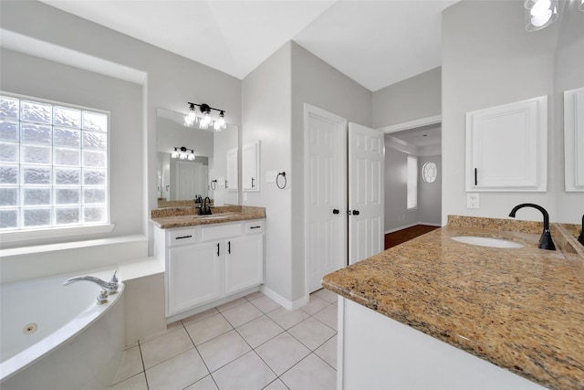 bathroom featuring two vanities, tile patterned flooring, a sink, and a bath