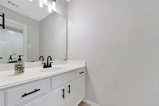 bathroom featuring baseboards, visible vents, and vanity