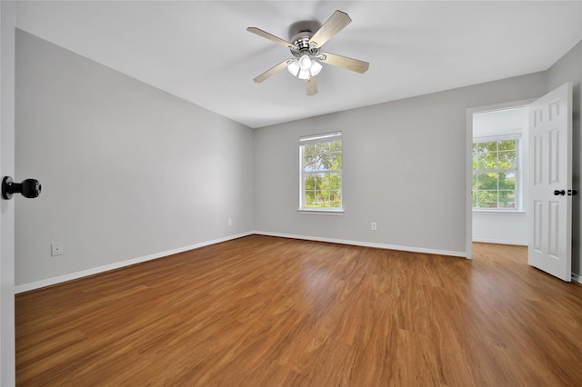 spare room with ceiling fan, wood finished floors, and baseboards