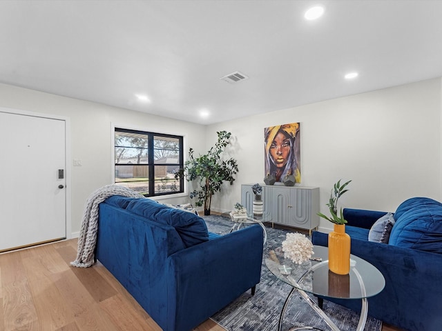 living room featuring recessed lighting, visible vents, baseboards, and wood finished floors