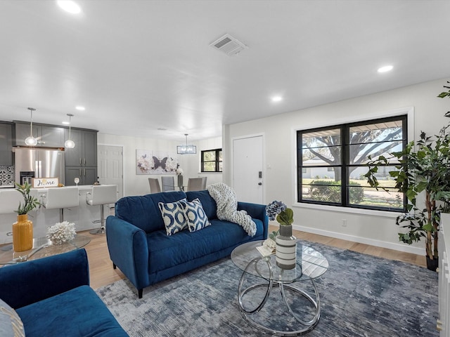 living room with light wood-style floors, recessed lighting, visible vents, and plenty of natural light