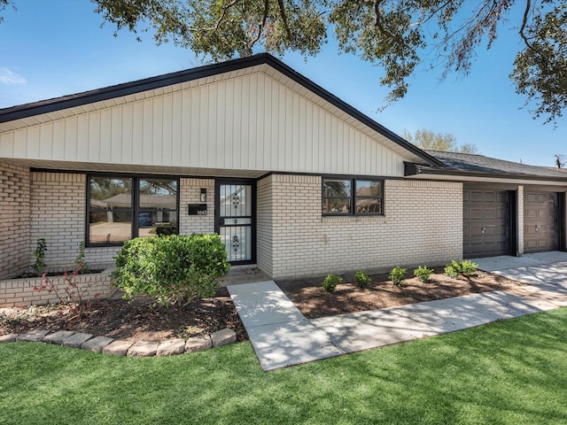 ranch-style house with an attached garage, a front yard, and brick siding