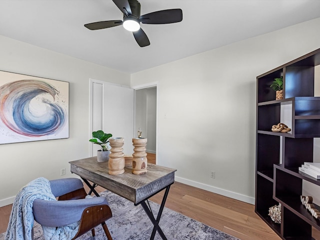 office area with a ceiling fan, baseboards, and wood finished floors