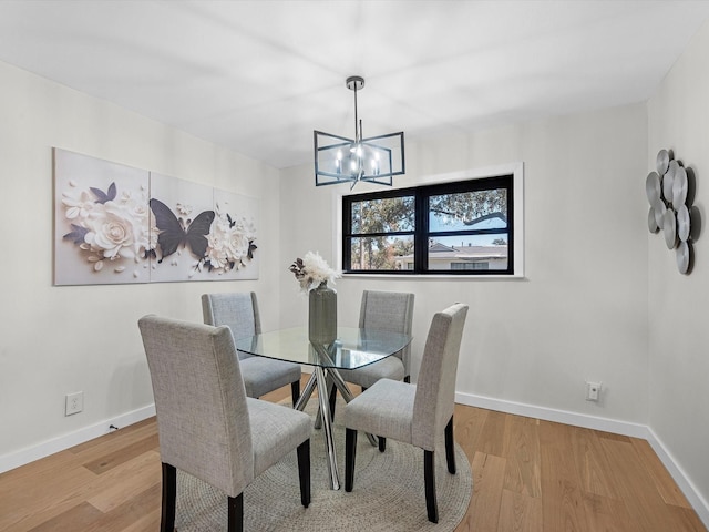 dining room featuring an inviting chandelier, wood finished floors, and baseboards