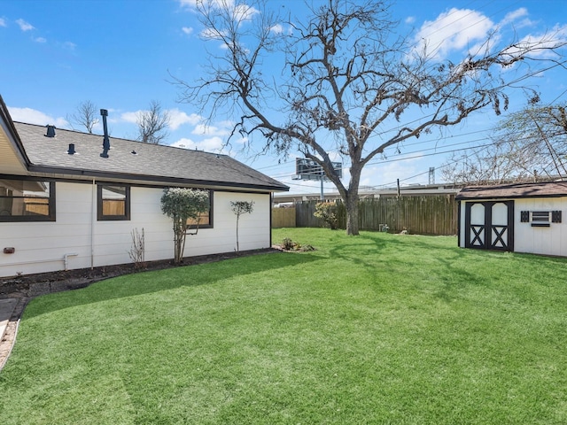 view of yard featuring a storage shed, fence, and an outdoor structure