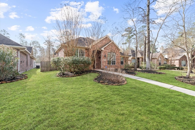 view of front of property with fence, a front lawn, and brick siding