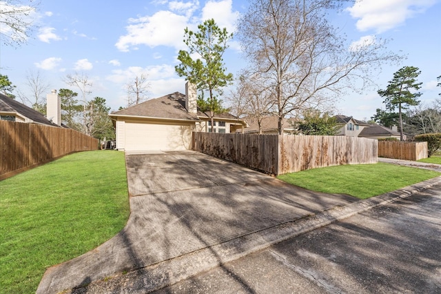 view of front facade with concrete driveway, a front lawn, and fence private yard