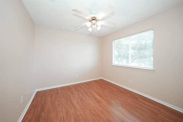 unfurnished room with ceiling fan, baseboards, and wood finished floors