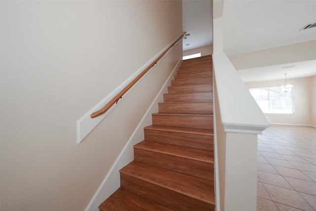 stairway featuring a chandelier, tile patterned flooring, and visible vents