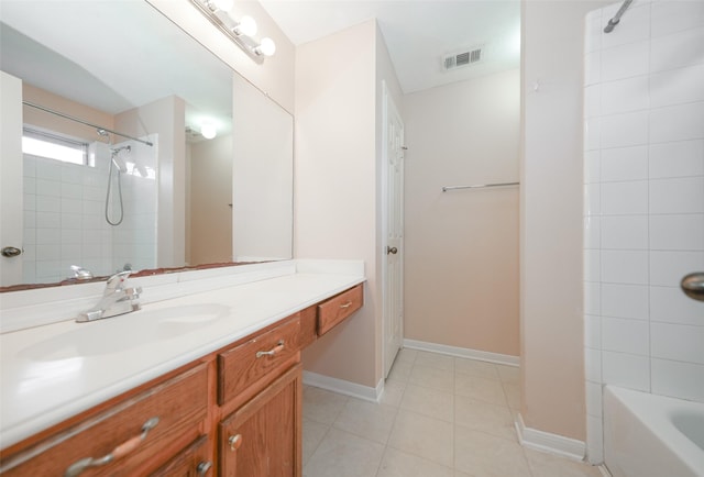 full bath featuring visible vents, baseboards, tile patterned flooring, vanity, and washtub / shower combination