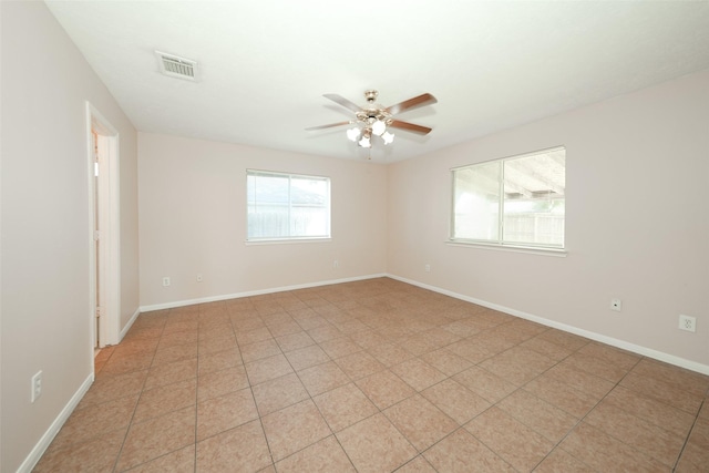 spare room featuring baseboards, visible vents, and a ceiling fan