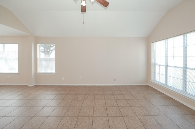 empty room featuring plenty of natural light, baseboards, and vaulted ceiling