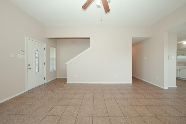 foyer entrance with ceiling fan, baseboards, and light tile patterned floors