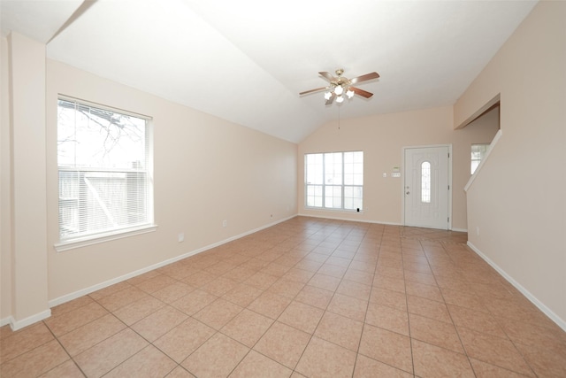 interior space with vaulted ceiling, ceiling fan, baseboards, and light tile patterned floors