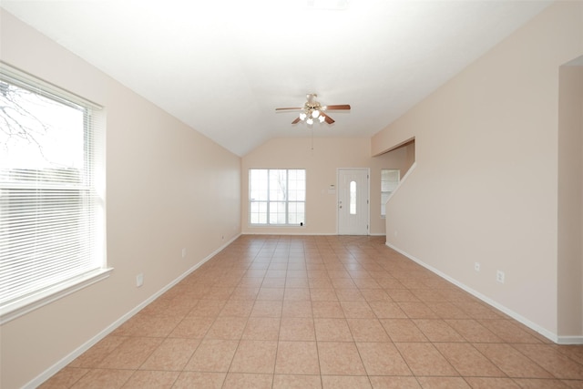 unfurnished room featuring lofted ceiling, light tile patterned floors, baseboards, and a ceiling fan