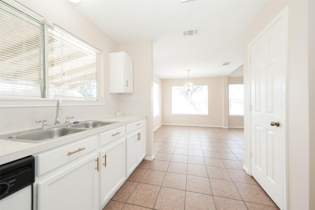 kitchen featuring a sink, light tile patterned floors, light countertops, and dishwasher