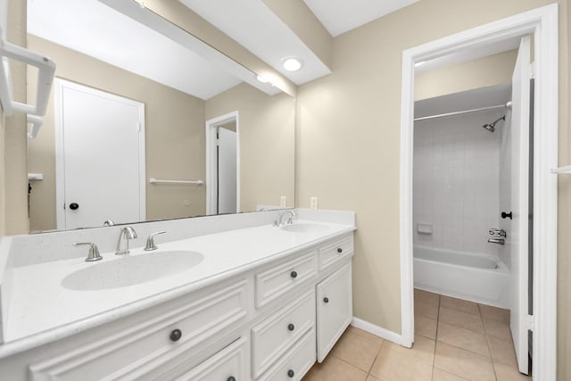 bathroom featuring double vanity, baseboards, a sink, and tile patterned floors