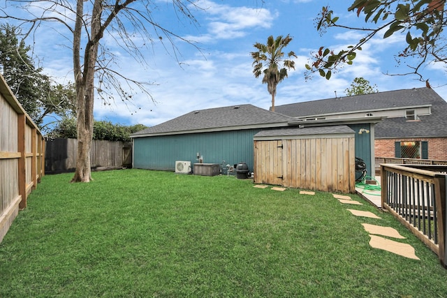 view of yard with a fenced backyard, an outdoor structure, and a storage unit