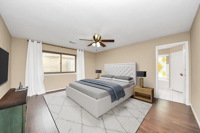 bedroom with ceiling fan, wood finished floors, visible vents, and baseboards