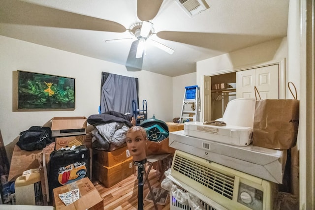 interior space with ceiling fan, visible vents, and wood finished floors