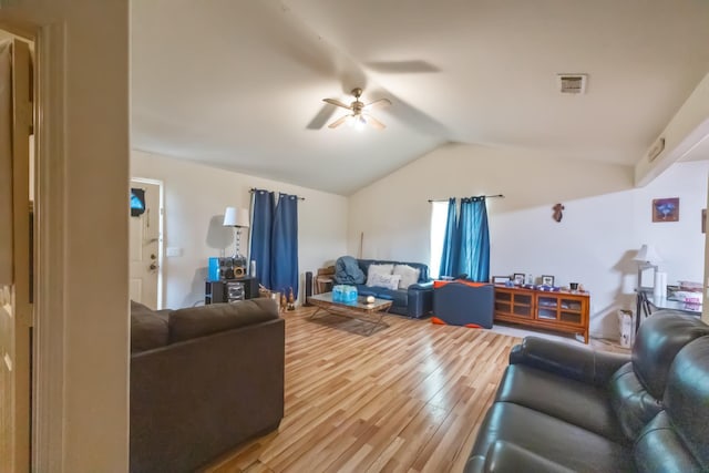 living room with a ceiling fan, lofted ceiling, visible vents, and wood finished floors