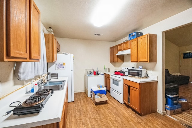 kitchen with visible vents, light countertops, light wood-style flooring, white appliances, and under cabinet range hood