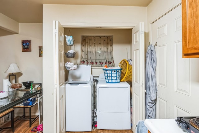 clothes washing area with laundry area, wood finished floors, and independent washer and dryer