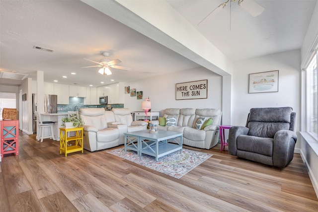 living room with light wood-style floors, recessed lighting, a ceiling fan, and visible vents