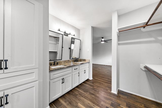 bathroom with double vanity, ceiling fan, a sink, and wood finished floors